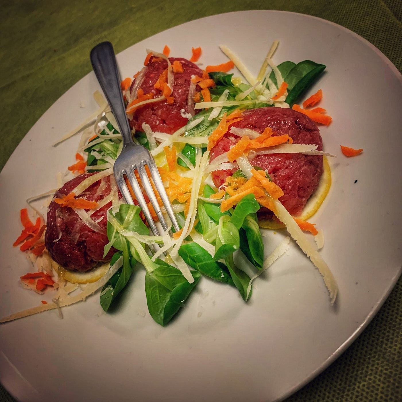 Hand-chopped raw veal with salad, carrot and shaved cheese