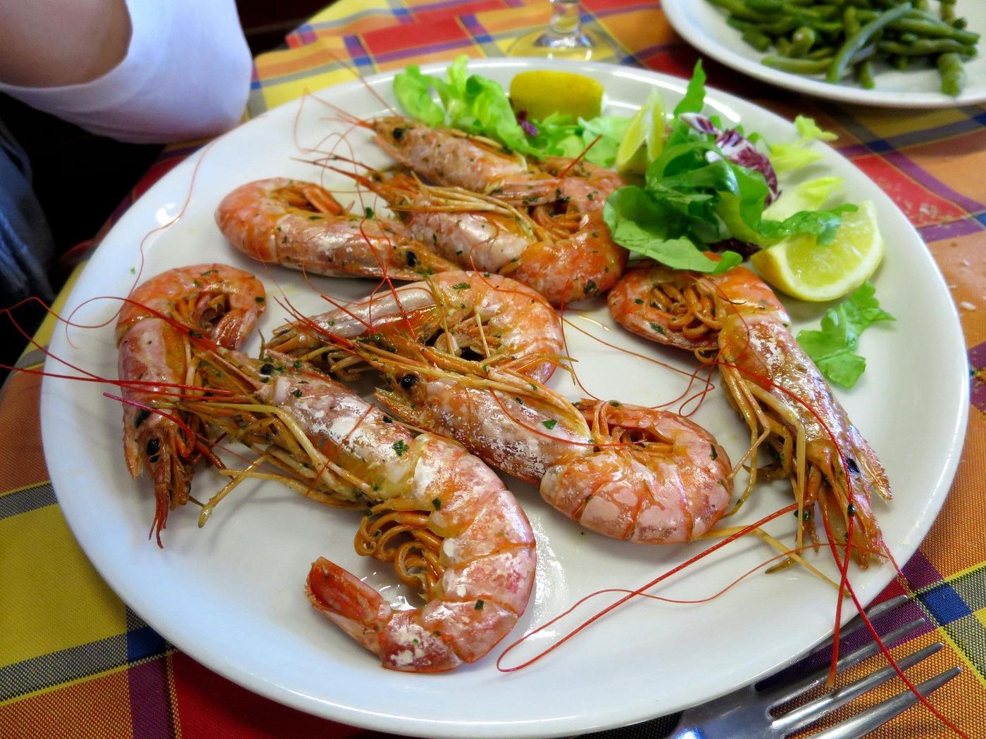 Plate of grilled king prawns with salad and lemon