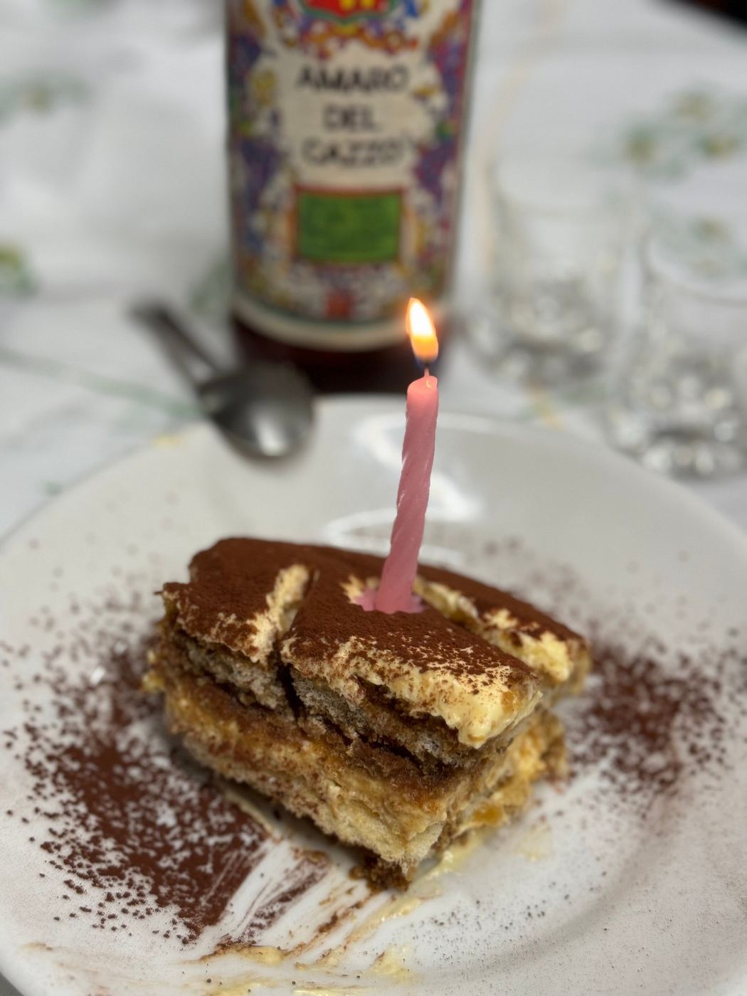 Slice of tiramisù with a lit birthday candle